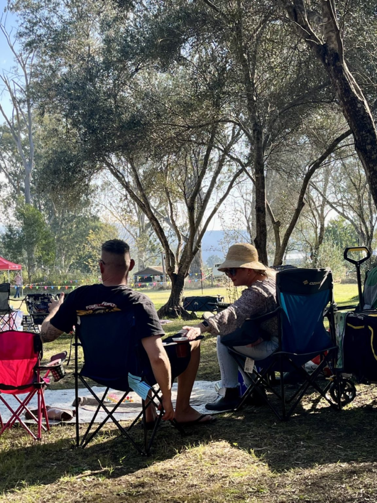 People sitting on chairs, relaxing under the trees